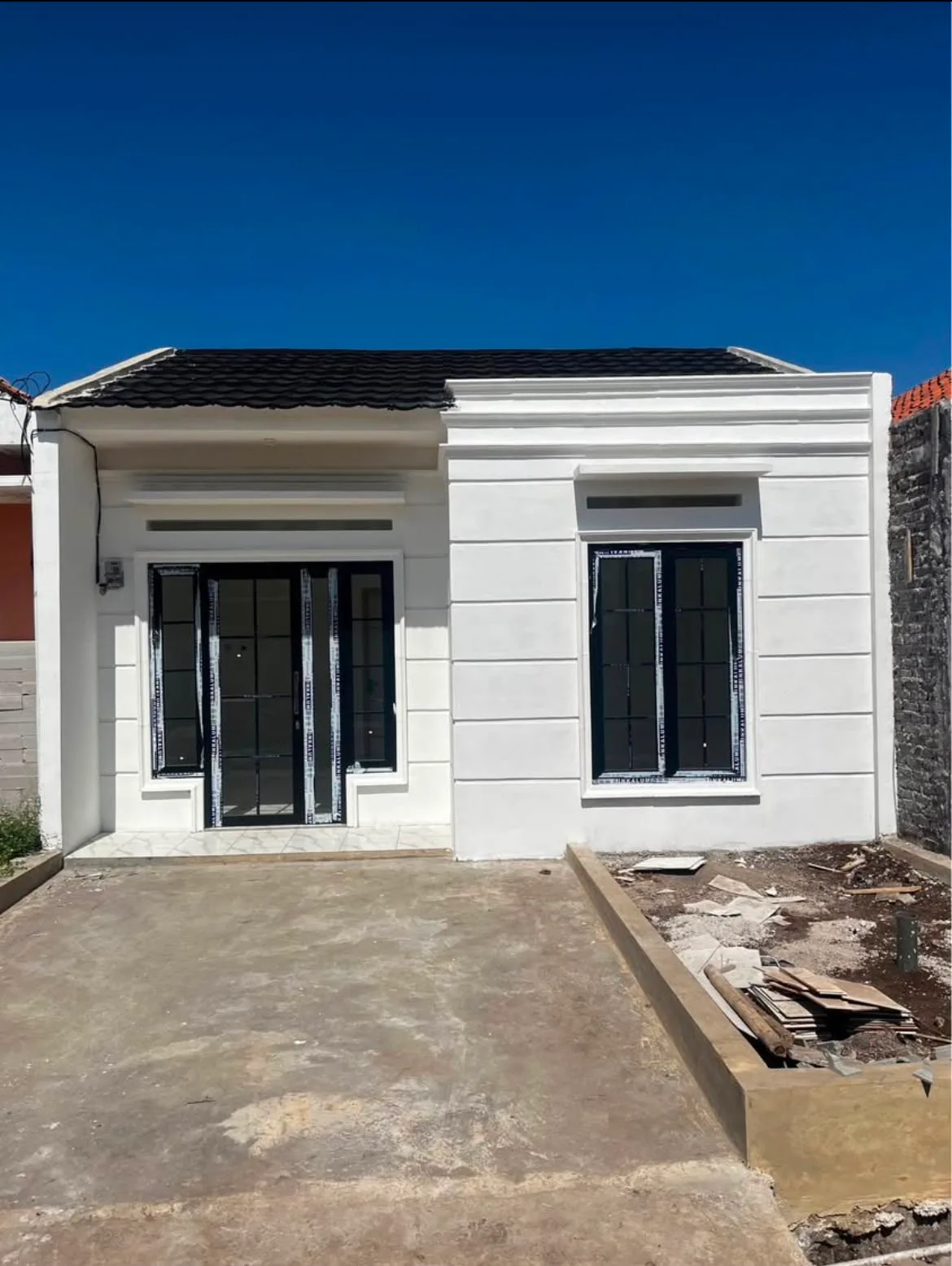 Fasad rumah modern bernuansa putih dengan halaman depan